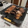 Brasero de mesa premium servido en la mesa con chorizos y carne