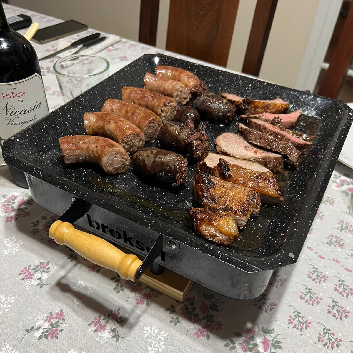 Brasero de mesa premium servido en la mesa con chorizos y carne