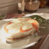 Pizza de muzzarella sobre la pala pizzera de carga perforada