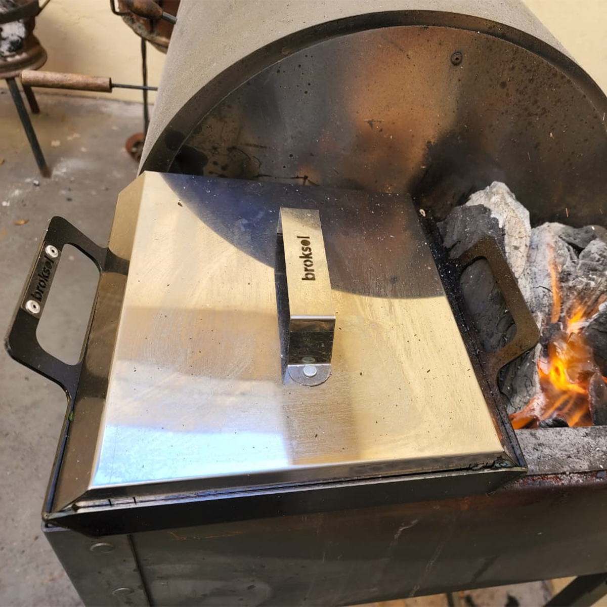 Tapa universal colocada sobre la plancha bifera en la parrilla