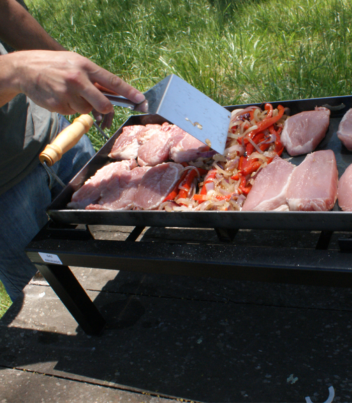 Dando vuelta carne en la plancha bifera premium sobre la parrilla