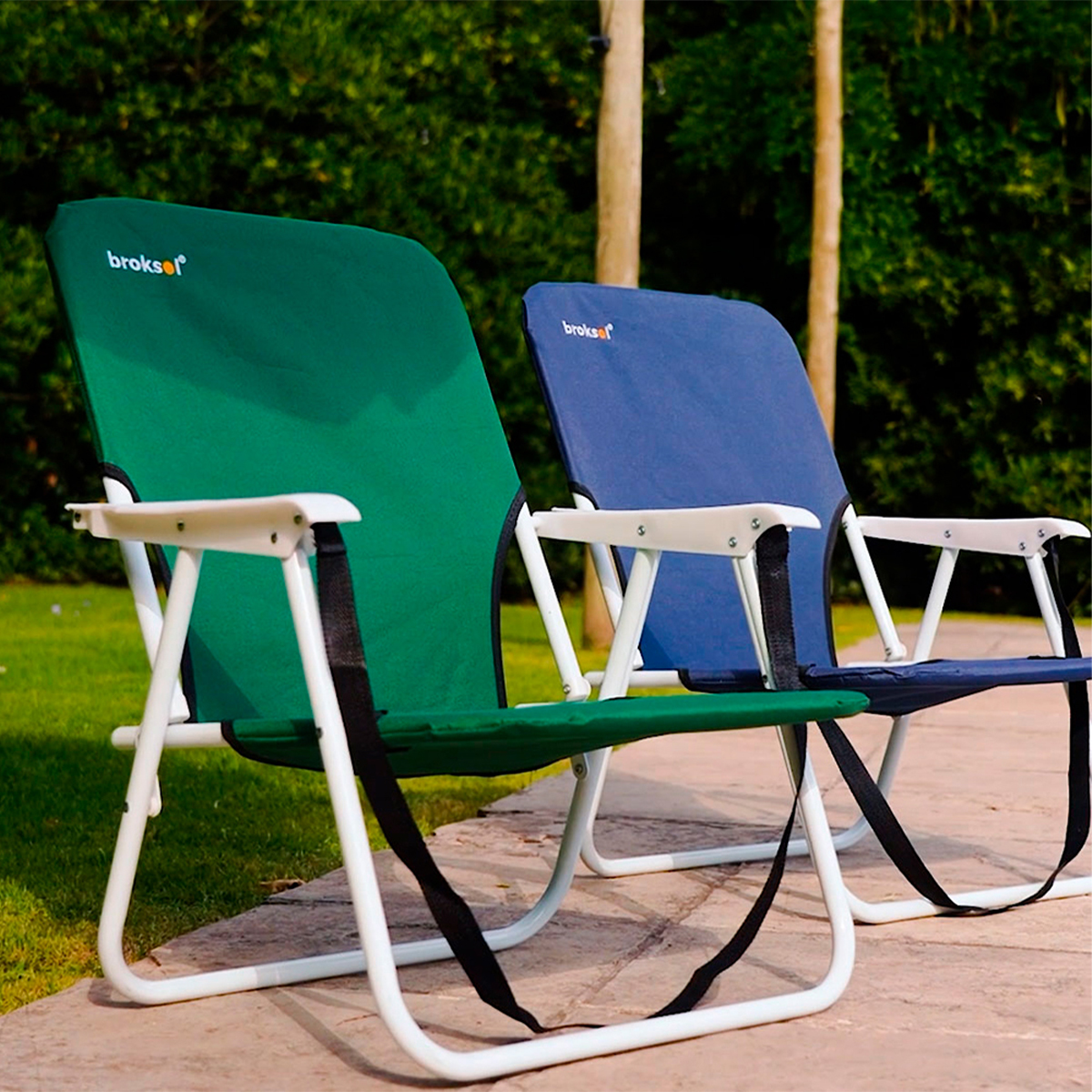 Sillones playeros bajos verde y azul en un jardín