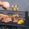 6115-CONTEXTO.jpg Pinza parrillera tomando un limón sobre la parrilla con carne