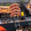 6121-CONTEXTO.jpg Pinche parrillero sosteniendo chorizos sobre la parrilla